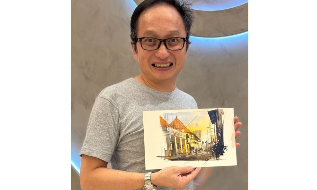Photo of Artist and urban sketcher holing up some of his work