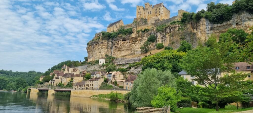Landscape of the Périgord region showing a castle at the top of a hill above a river