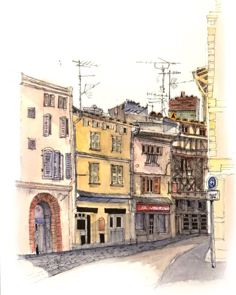 Pen-and-watercolour sketch by Patty Edge of a quiet European street lined with colourful historic buildings.Toulouse